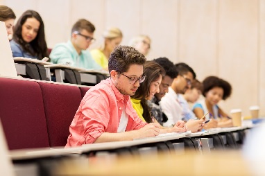 Students working at desks in auditorium