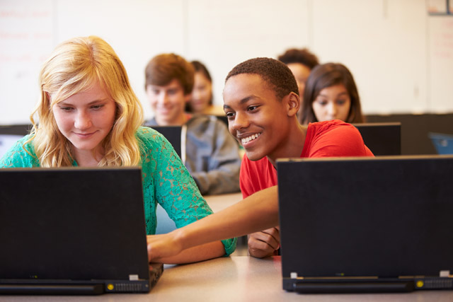 High School students typing on computer