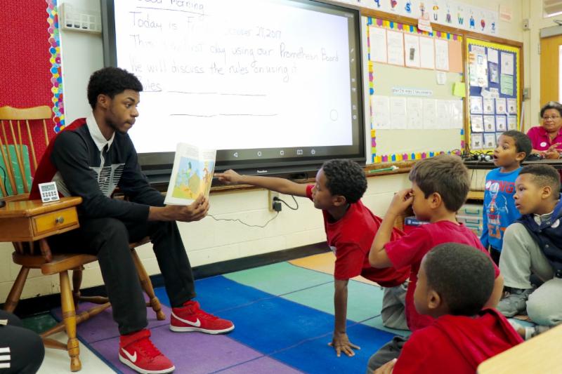 Student mentor reading to younger students mentor