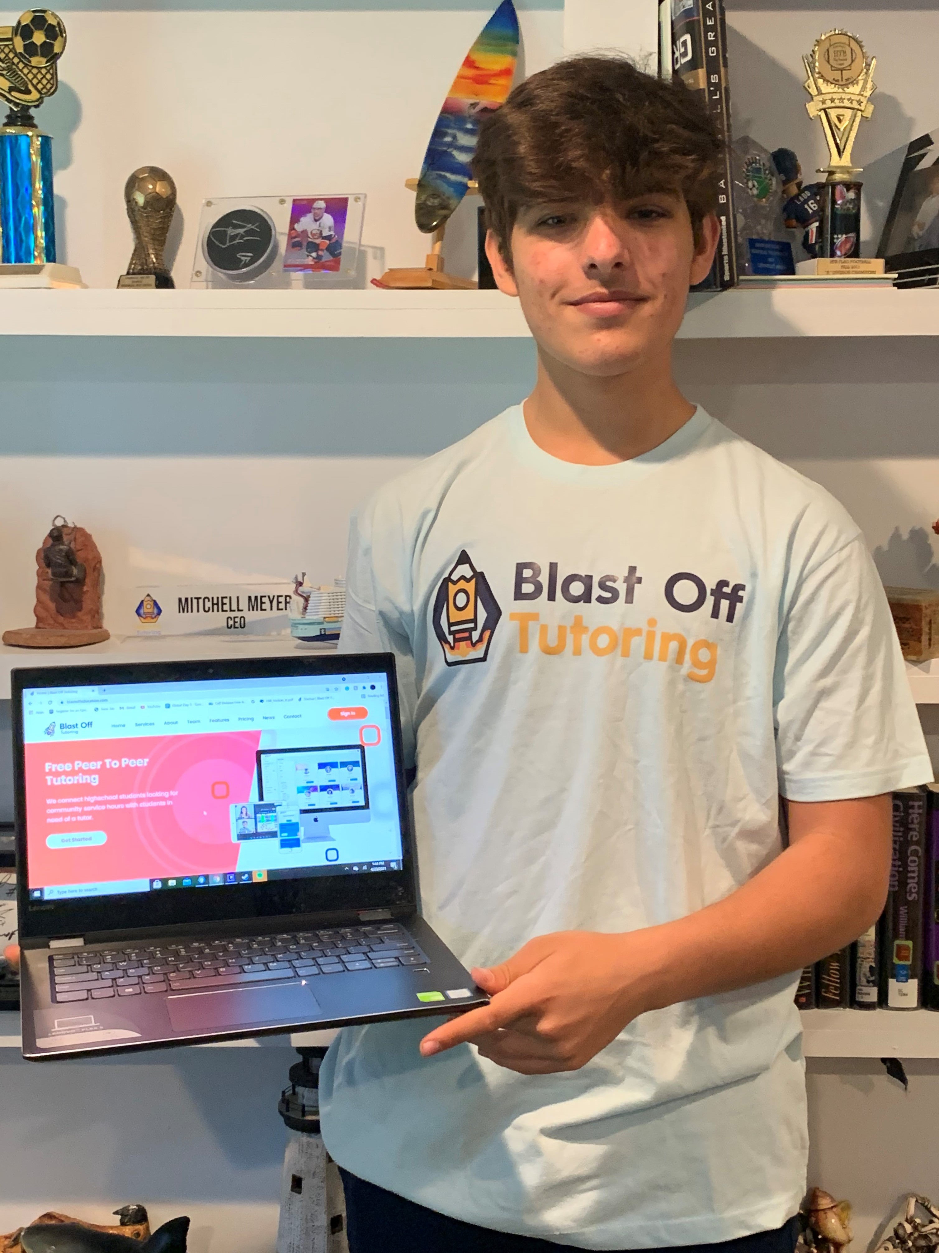 Student holding laptop with his website