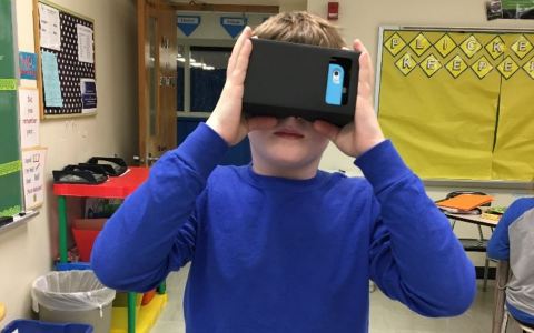 A student using his phone to experience virtual reality.