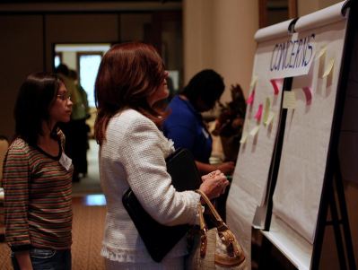 Attendees at a budget meeting viewing a poster