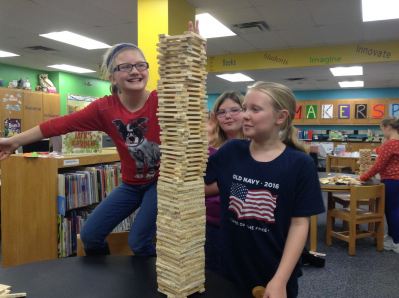 Fourth graders using KEVA Planks to make the tallest and widest structure