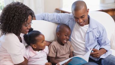 Parents reading book to children
