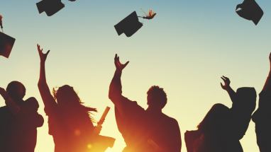 graduates throwing caps in the air