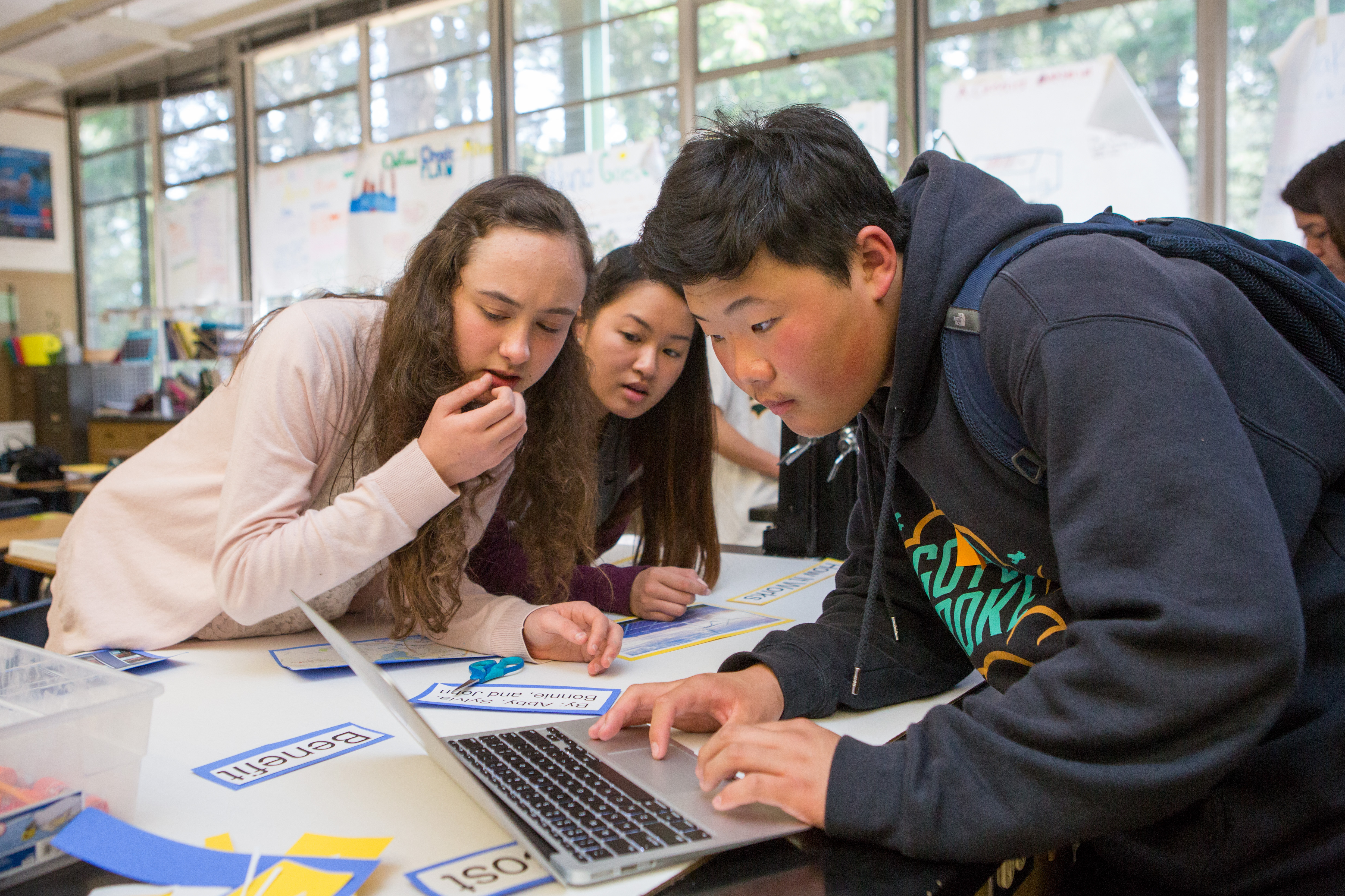 Students gathered around a laptop