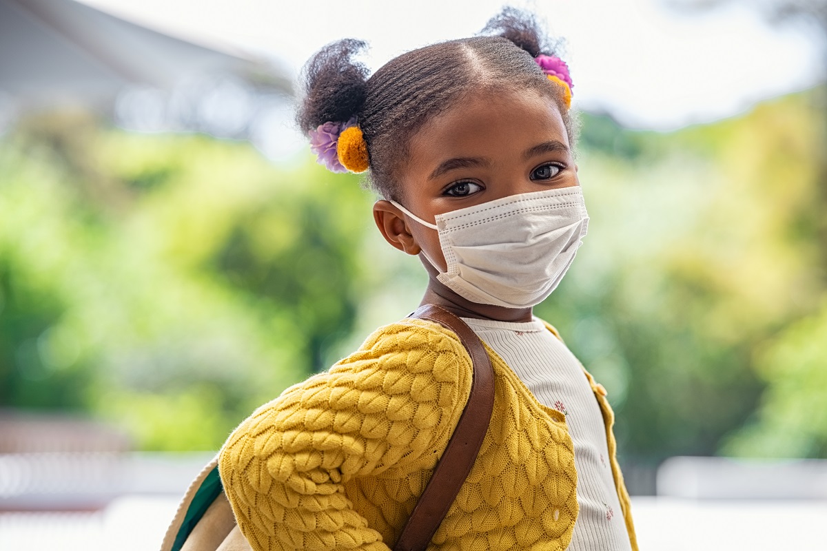 young student wearing mask and backpack