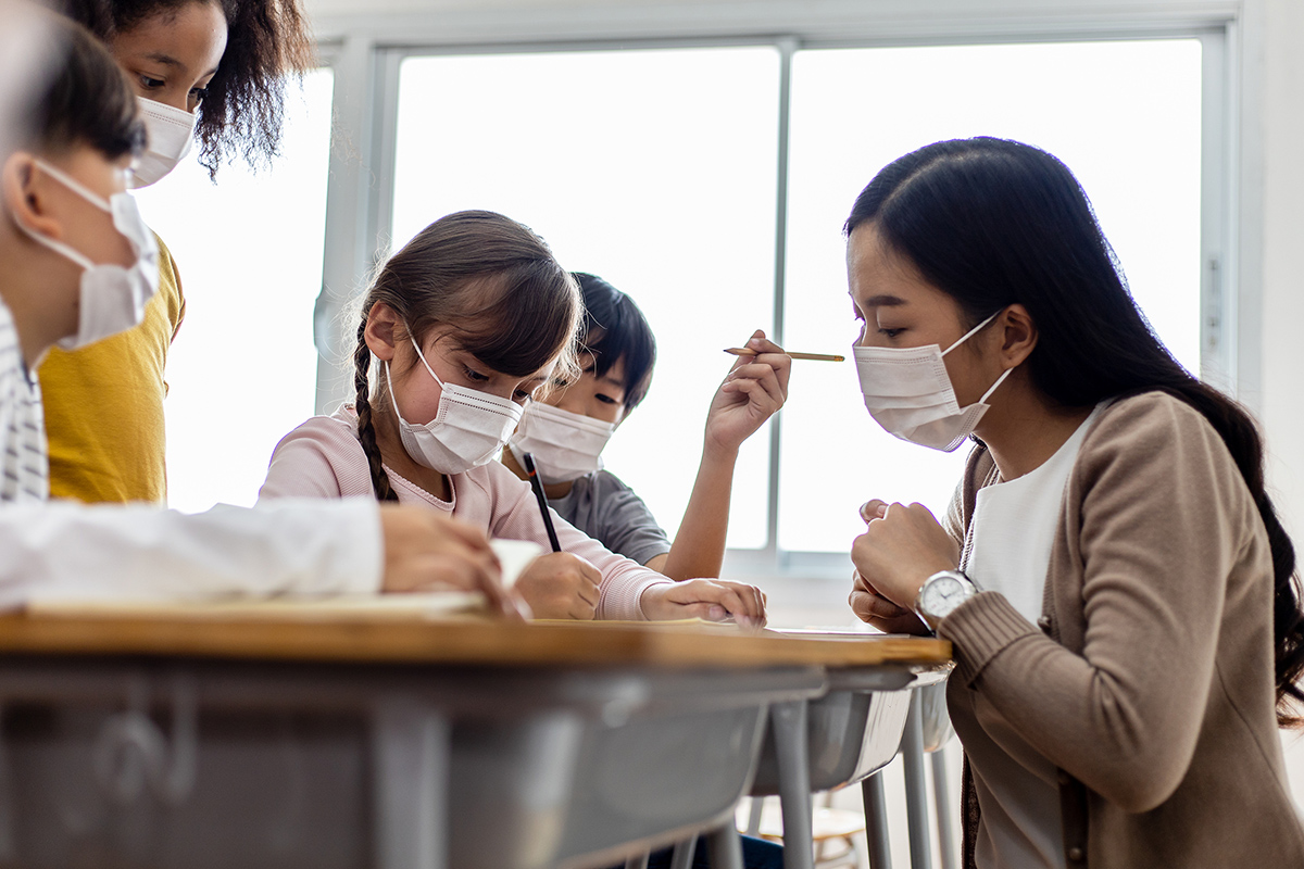 Teacher helping students at their desks