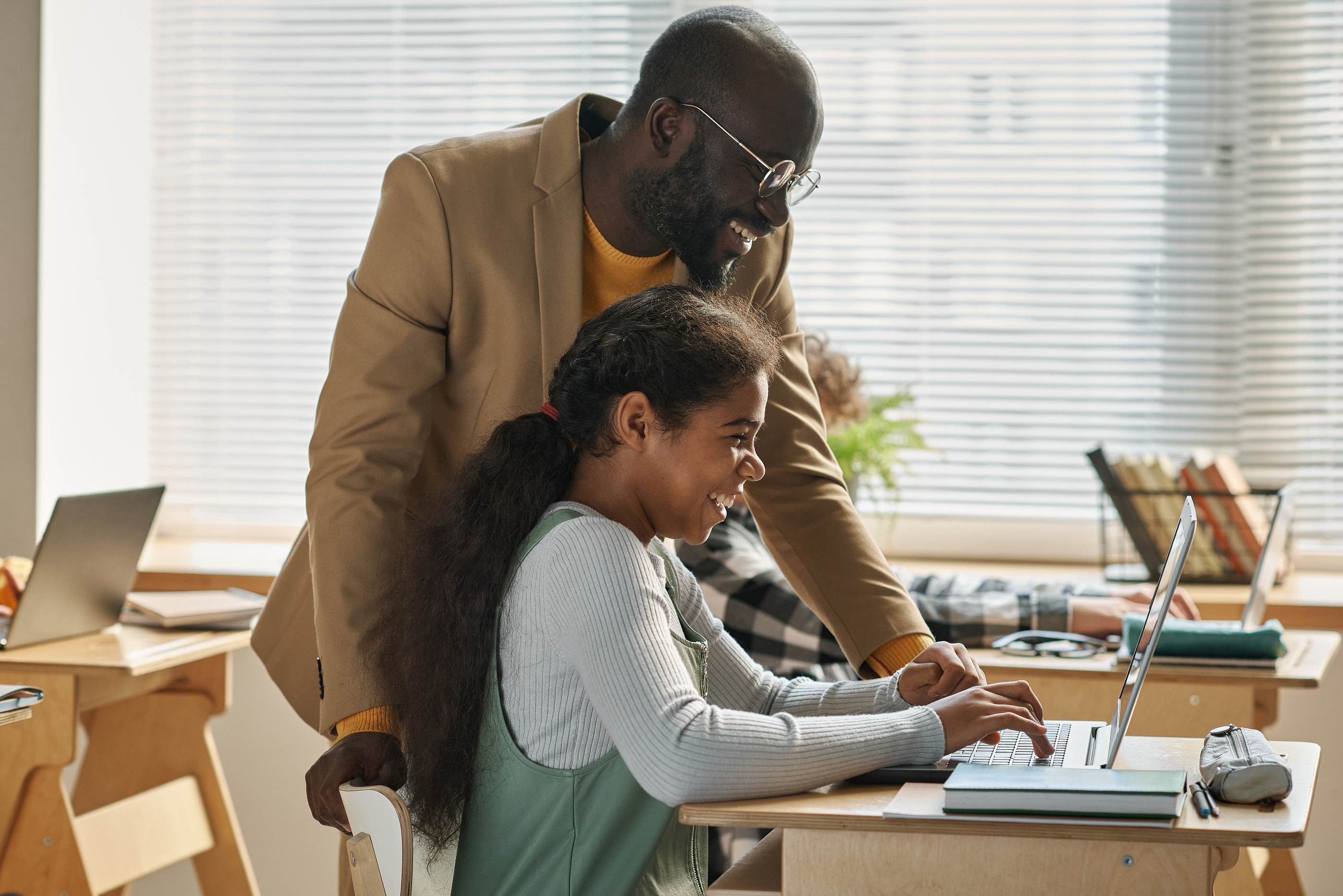 Student and teacher in front of a computer