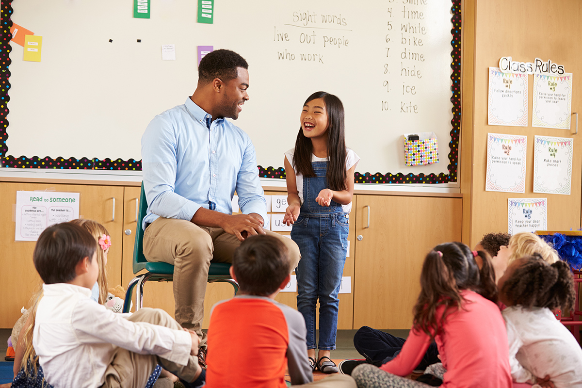 Teacher with student at front of class