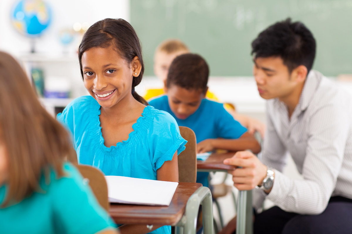 Teacher working with student at desk