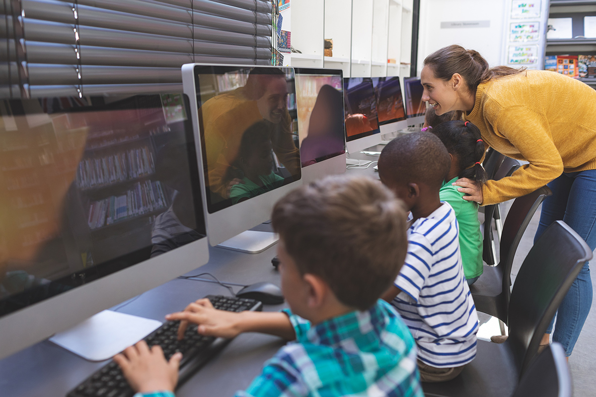 Teacher working with students at computers