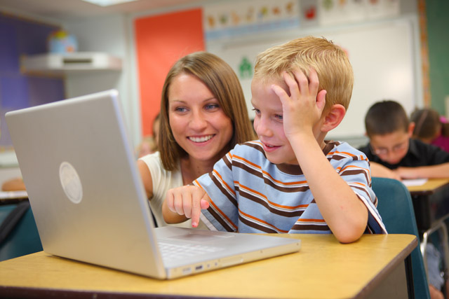 Student and teacher using a laptop