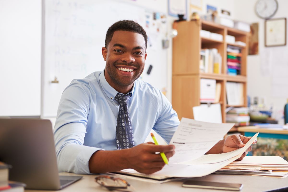 smiling teacher at desk