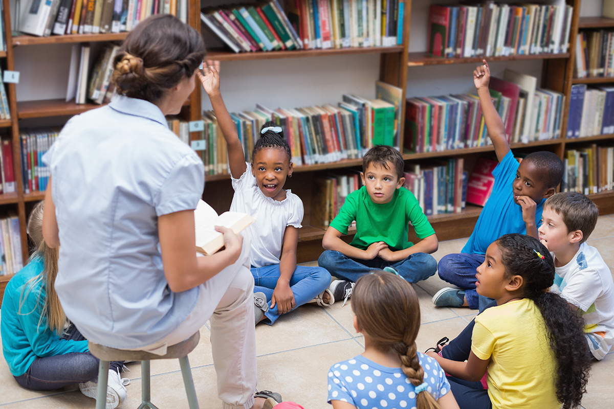 Teacher reading to students in library