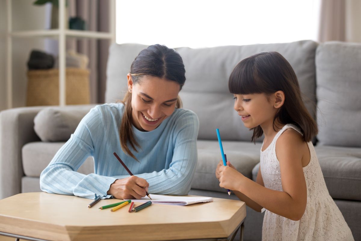 mother and preschool daughter writing