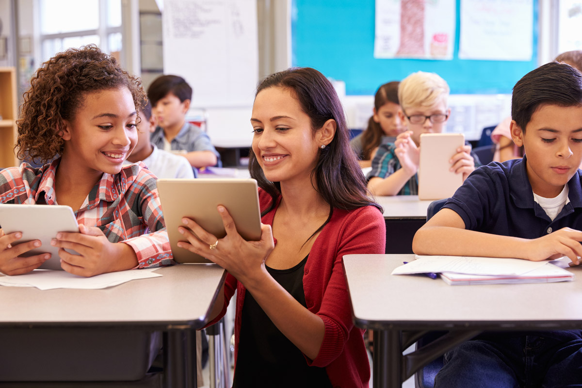 Teacher helping student with computer