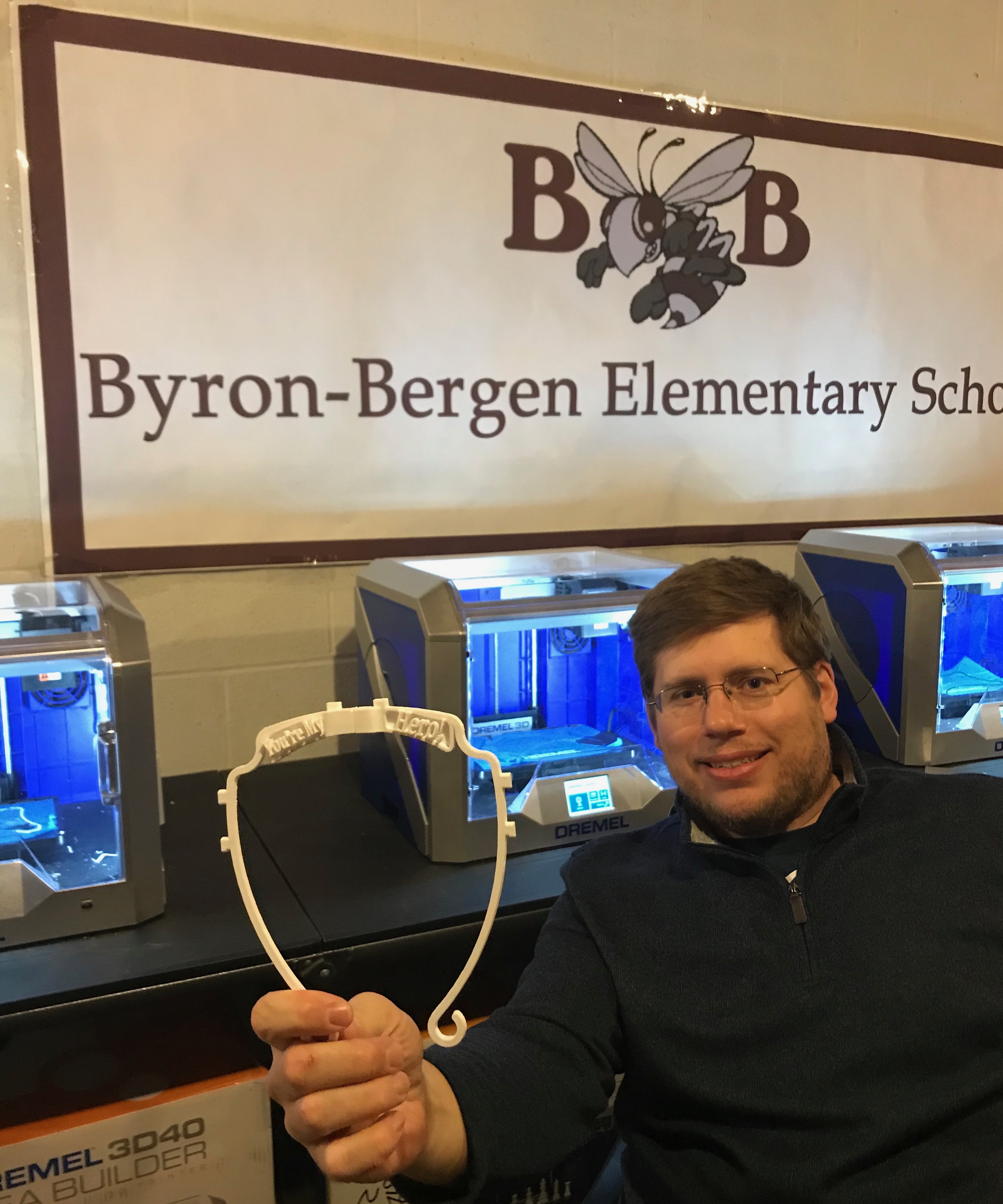 STEAM Lab Teacher Craig Schroth holds up a section of a completed face shield 