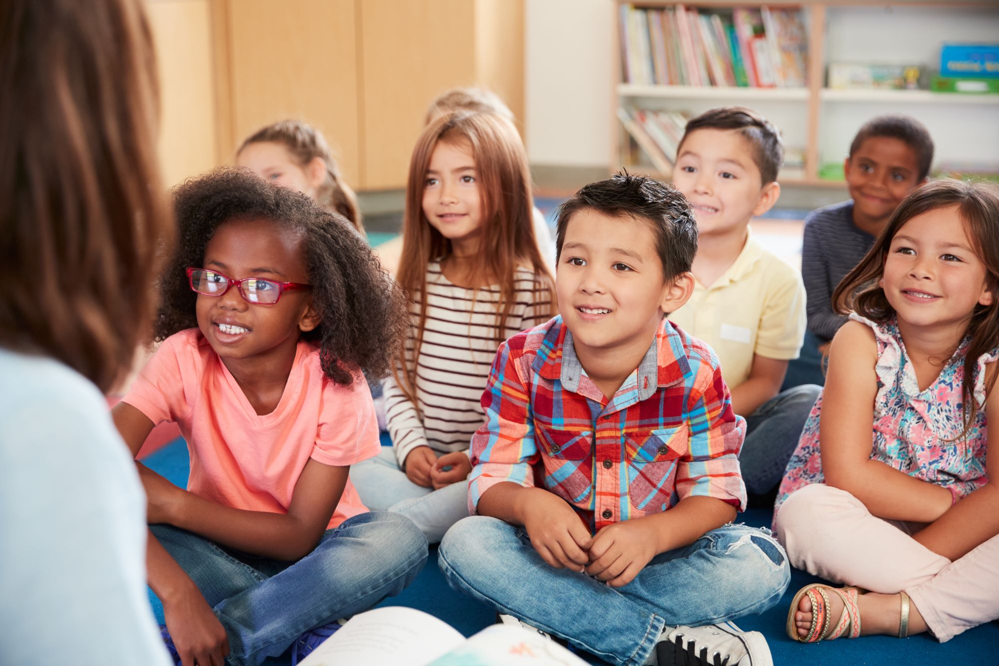 students sitting on floor listening to teacher