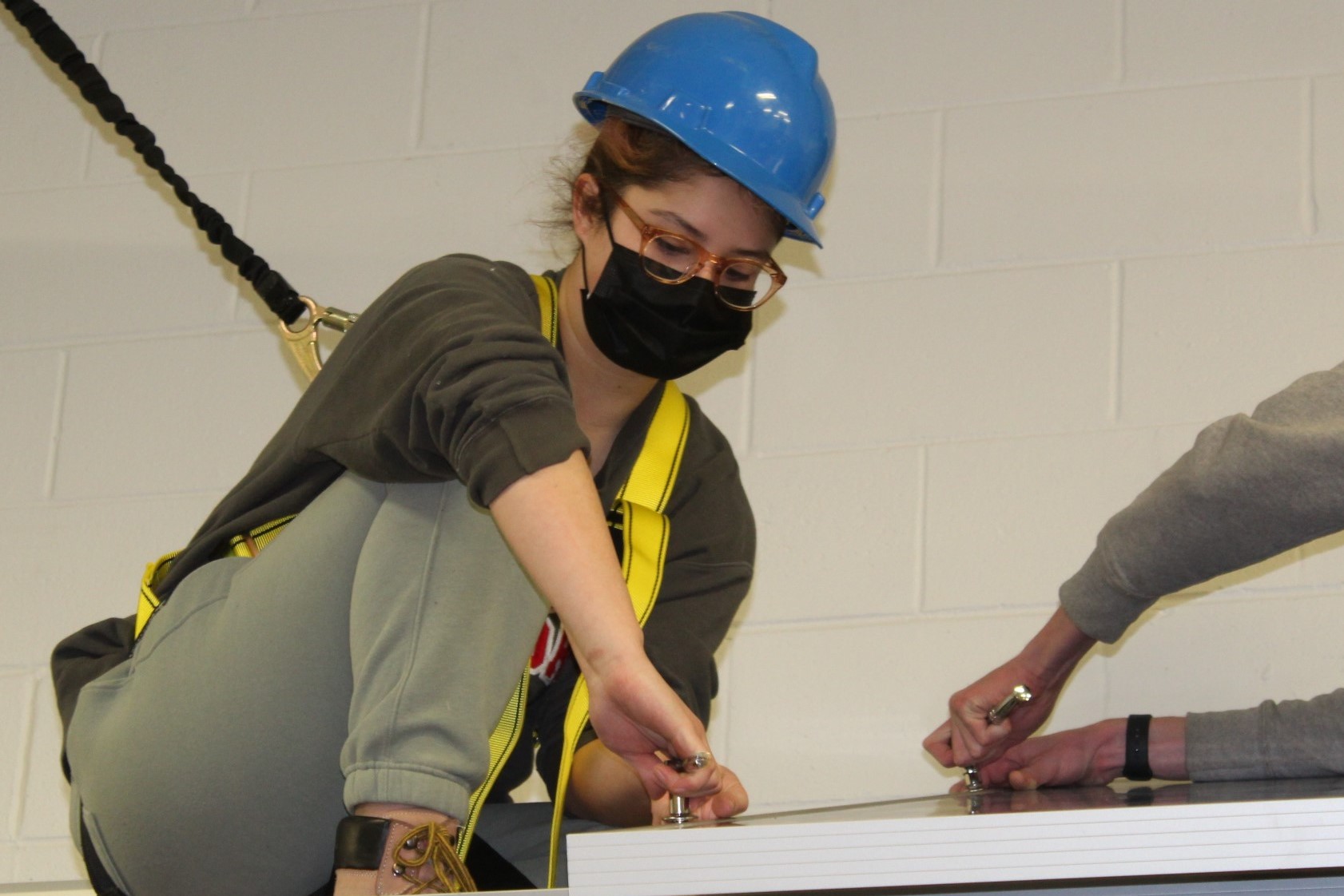 Student installing solar panel in classroom environment