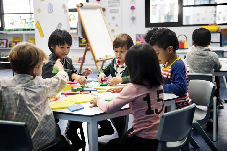 Young students working with shapes and toys at a table