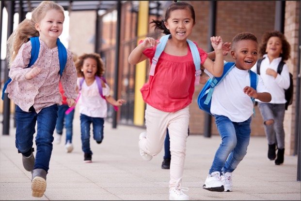 Preschool students smiling and running towards school.