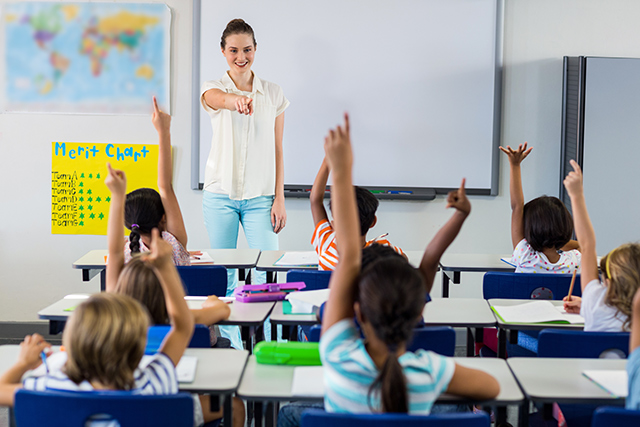 Teacher and students raising hands