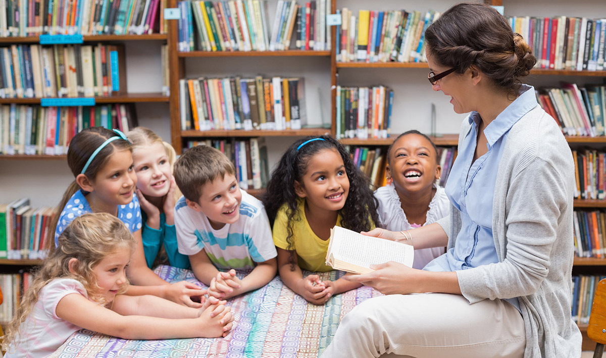 Teacher reading book with students