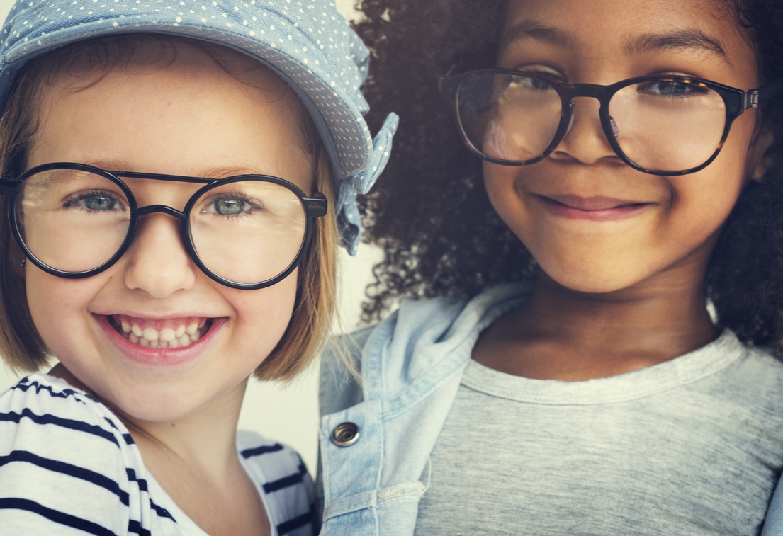 two smiling students wearing glasses