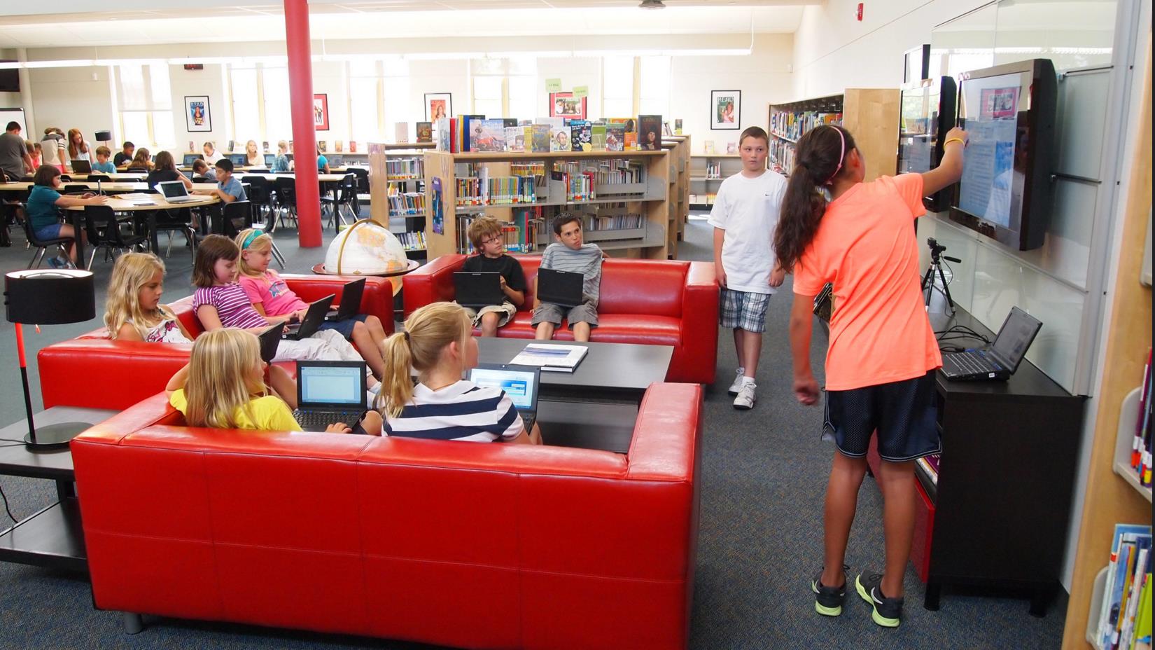 Students working together on a project at a library using modern technology