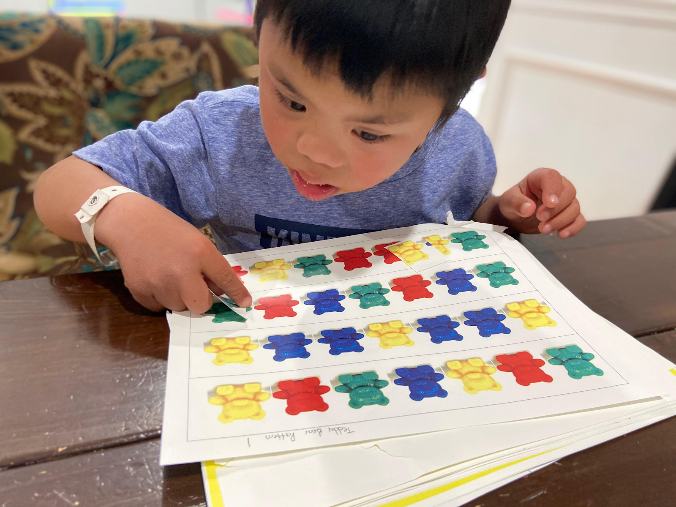 Student pointing to image of teddy bear manipulatives arranged in patterns