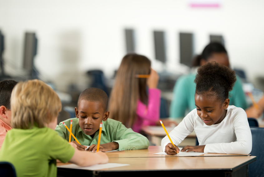 students writing with pencils