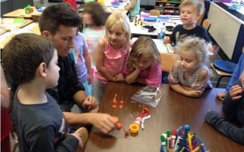 Noah L., a high schooler, completing a STEM bin challenge in one minute with the first grade class. 