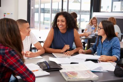 Teacher and students sitting at a table.