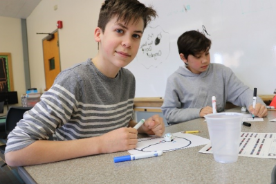 Student practices drawing a circle track for the robot to follow.