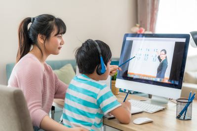 Mother helping child working on math at computer