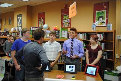 Students presenting to teachers, parents and community members in a library about the Constitution