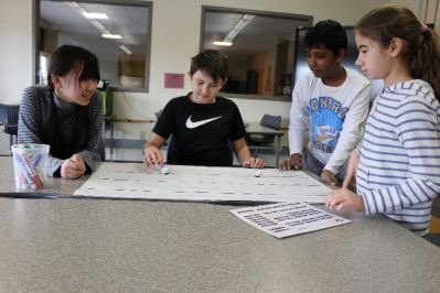 Four students race two ozobots on different tracks.