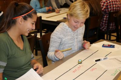 Two students run a time trial on the snail dose track of their ozobot robot.