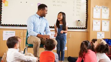 Teacher with student at front of class