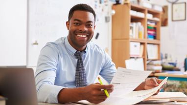smiling teacher at desk