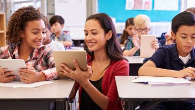 Teacher helping student with computer