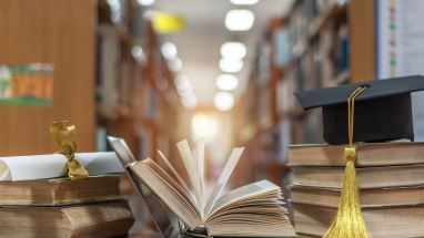 laptop and stack of books in library