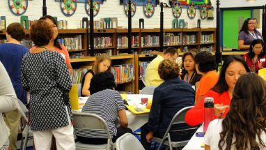 Teachers and staff gathered for an event in a library