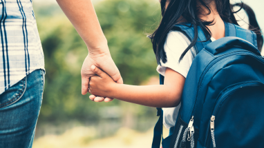 student and parent holding hands
