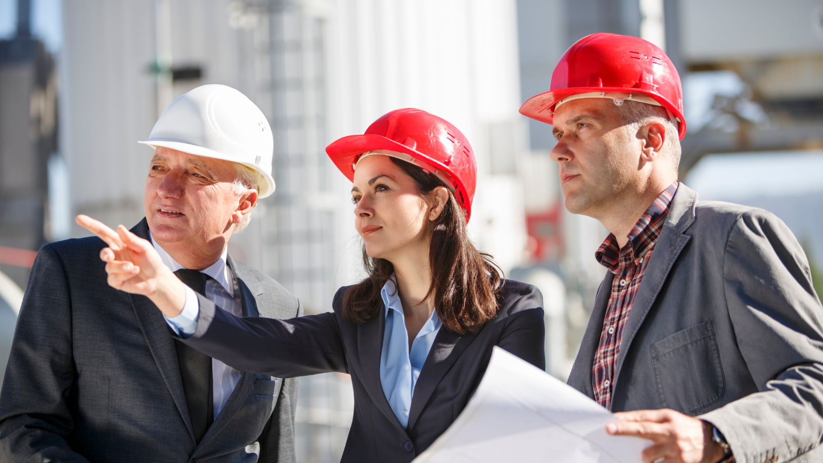Three workers planning and pointing